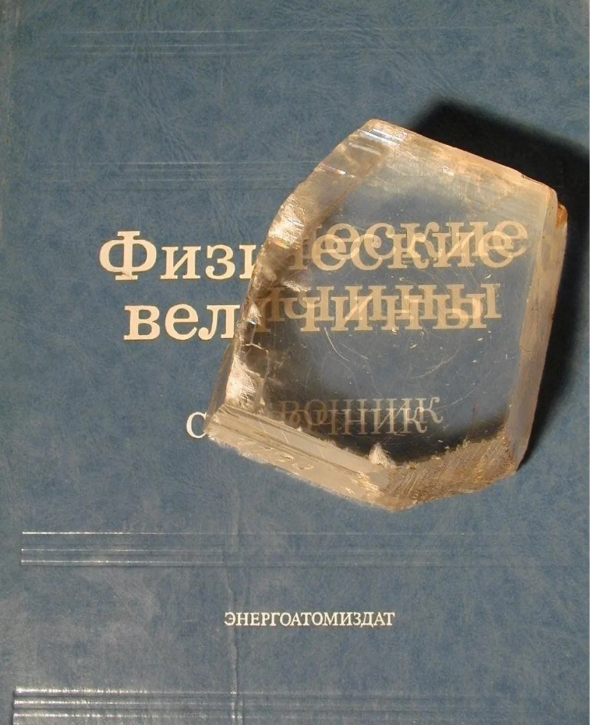 Кристалл исландского шпата (CaCO₃) на обложке книги: надпись под ним раздваивается